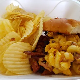 The Mackdaddy - smoked pork or chicken w/ choice of BBQ sauce topped w/ mac-n-cheese on a toasted bun, served w/chips.