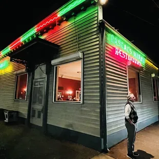 a man standing in front of a restaurant