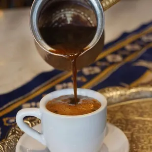 a coffee being poured into a cup
