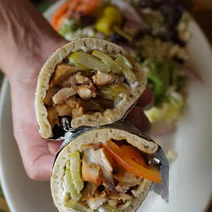 a hand holding a burrito