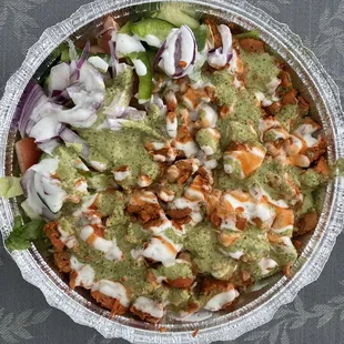 Chicken over rice with white red green sauce