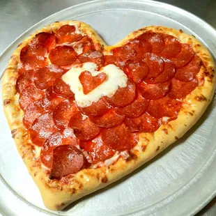 a heart shaped pepperoni pizza