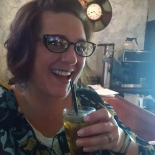 a smiling woman holding a drink