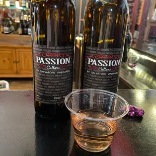 two bottles of passion and a glass of wine