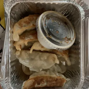 a container of dumplings and sauce