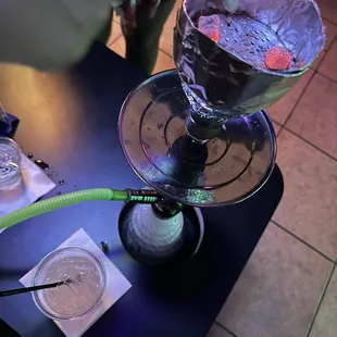 a person pouring liquid into a hookah