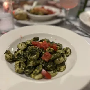 a plate of pasta with tomatoes and spinach