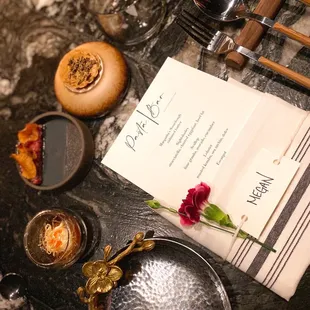 a menu, wine glasses, and a plate of food