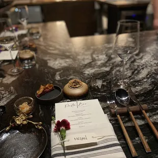 a menu, wine glasses, plates and utensils