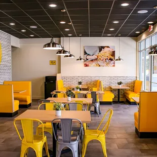 a dining area with yellow chairs