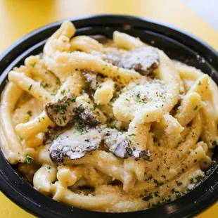 a bowl of pasta with mushrooms and parmesan cheese