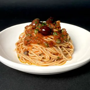 a plate of spaghetti with sauce and olives