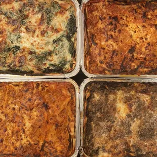 four pans of baked lasagna
