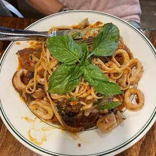 a plate of pasta with mushrooms and basil