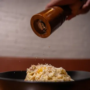 a hand sprinkled with cheese