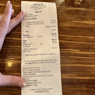 a person&apos;s hand holding a receipt