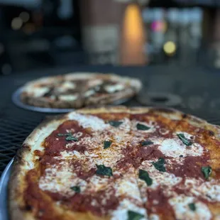 two pizzas on a table