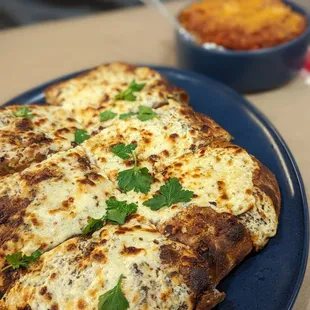 a blue plate with a cheesy pizza on it