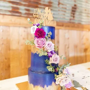 a three tiered cake with purple and pink flowers