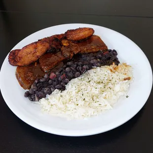 Blackened roast, fried plantains, black beans and white rice