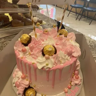 Pink and white drizzle cake with chocolate and candies