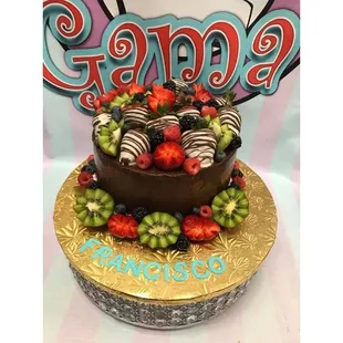 a chocolate cake decorated with strawberries, kiwis, and strawberries