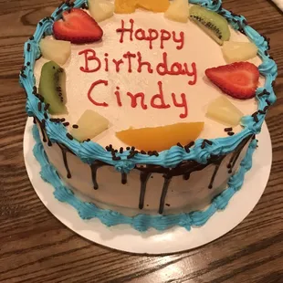 a birthday cake decorated with fruit