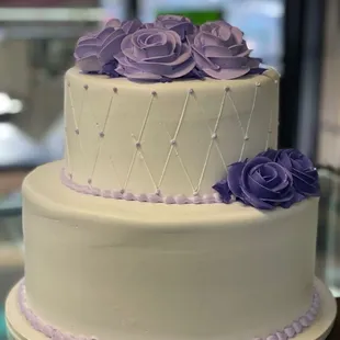 a wedding cake with purple roses