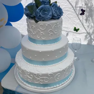 a wedding cake with blue roses