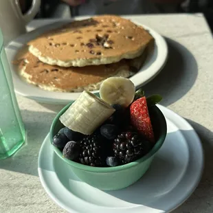 Two chocolate chip pancakes and cup of fruit