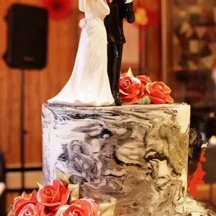 ows a bride and groom on top of a wedding cake