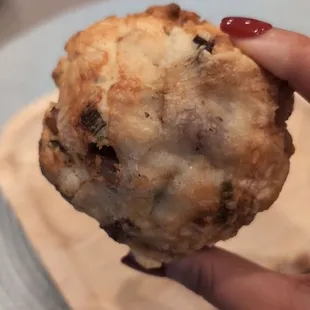 a hand holding a pastry on a plate