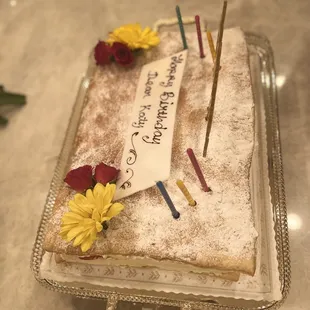 a birthday cake with candles and flowers