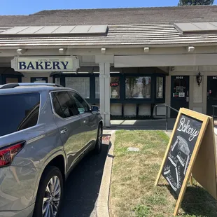 The door is to the right of the Bakery sign.