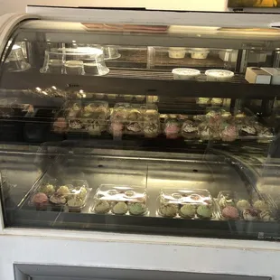 a display case filled with cupcakes