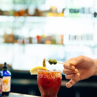 a bartender serving a bloody drink