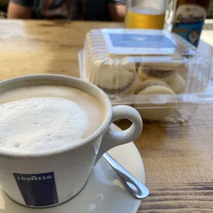 Cappuccino with Alfajorcito Cookies (Dulce de Leche Cookies Sandwich); Argentinian beer in the background