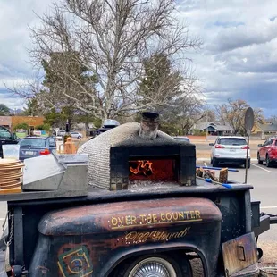 an old truck with a pizza oven