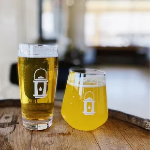 two glasses of beer on a barrel