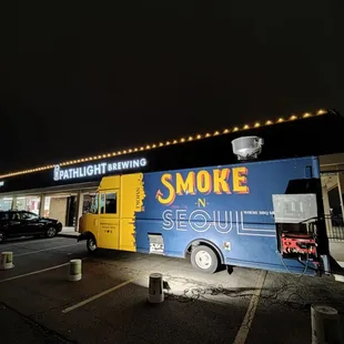 a blue and yellow food truck parked in a parking lot