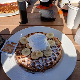 Waffle with sliced bananas and whipped cream