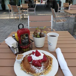 a plate of pancakes and a cup of coffee