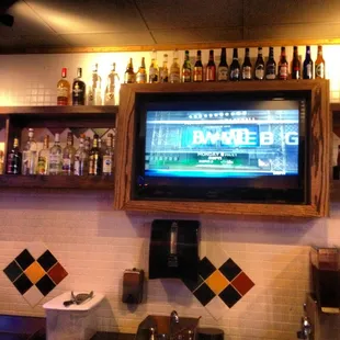 a flat screen tv mounted above a bar