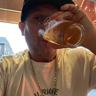 a man drinking a glass of beer