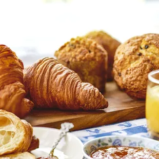 a breakfast of croissants, bread, jam and orange juice
