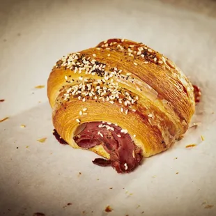 a pastry with meat and sesame seeds