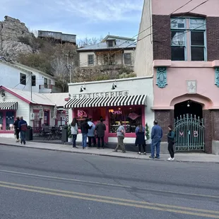 a group of people standing on the sidewalk