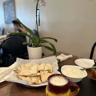 a plate of pita chips and a bowl of dip