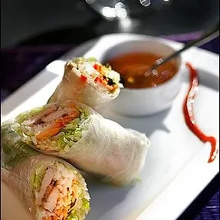 two rolls of food on a plate with dipping sauce