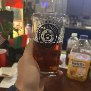 a person holding a glass of beer